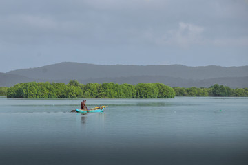 Fototapeta na wymiar fisherman with canoe on the lake at Trincomalee Sri Lanka
