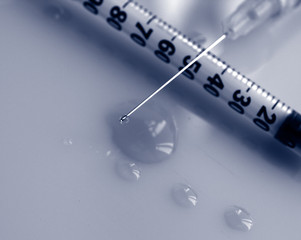 Antobiotics medication concept: close up of syringe's needle loaded with medication