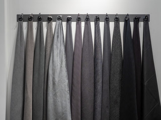 Wall rack with dark shades of gray and black materials of sample fabrics