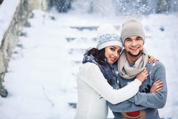 Fototapeta na wymiar man and girl in sweaters hugging in the park in winter. winter walk, rest.