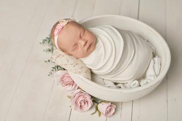 Cute newborn little girl sleeping in crib with flowers. Baby goods packaging template. Closeup...