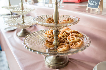 Waffle for Breakfast on the Buffet Table.  Miniature Waffles in a Warming Tray with Tongs at a Buffet in a Restaurant. Breakfast waffles on glass tray with black background