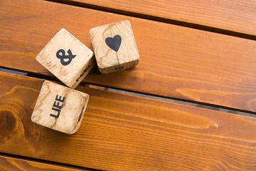 Wooden blocks with the words lie on the table. Wooden cubes with letters and symbols. Life for love.