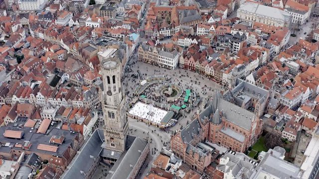 Aerial view of Bruges iconic Market Square with Belfry of Bruges medieval bell tower historical landmark in city town center famous Europe tourist destination in Belgium HD - 4K