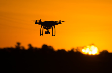 Silhouette of drone flying at sunset