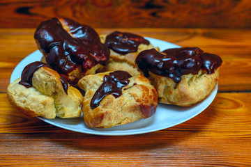 chocolate eclairs on a wooden background
