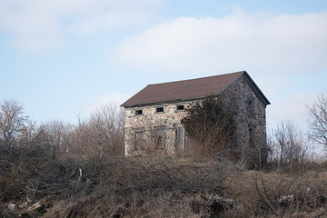 An old abandoned fieldstone building in a rural area in autumn