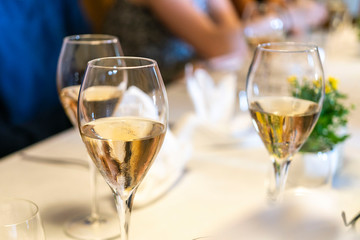 three glasses of white wine on a table with blurry background