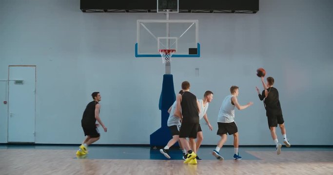High school team playing basketball indoors, practicing combinations and drills. 4K UHD