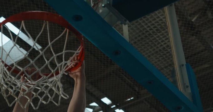 High school team basketball player practicing dunks indoors. 4K UHD