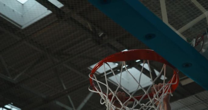 High school team basketball player practicing dunks indoors. 4K UHD
