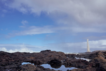 Fototapeta na wymiar Faro de Punta del Hidalgo, Tenerife Black Stone Coast overlooking the rough Atlantic Sea on a rainy day