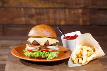 burger and french fries on the wooden table.