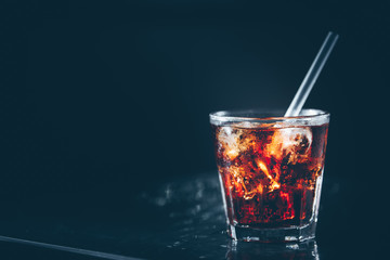 Cuba libre cocktail at the bar stand. Dark background