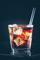 Cuba libre cocktail at the bar stand. Dark background