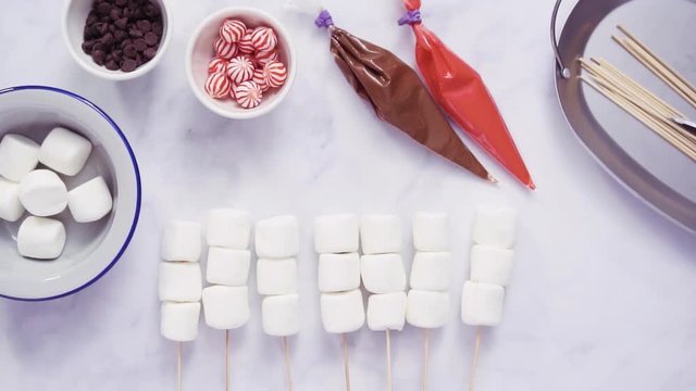Step by step. Flat lay. Making marshmallow snowman and reindeer on sticks hot chocolate toppers for food gifting.