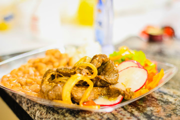 Dish with colorful food with rice, beans, meat, onion and salad. Selective focus. Brazilian food