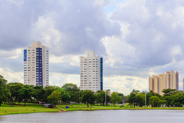 Fototapeta premium Partial view of the lake in the Parque das Nações Indígenas and buildings in the background, in the city of Campo Grande, capital of Mato Grosso do Sul, Brazil. City in the middle of nature