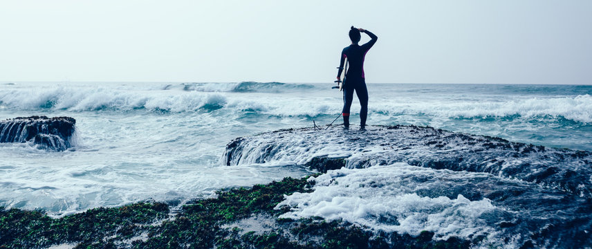 Woman surfe with surfboard on mossy coral reefs