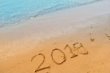 Happy new year concept, 2019 writing on sand beach.