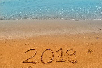 Happy new year concept, 2019 writing on sand beach.