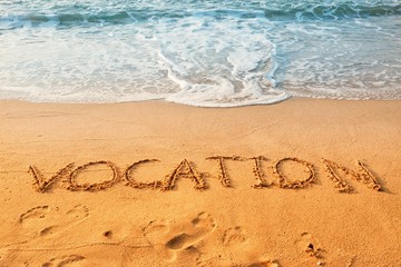 The word of vocation writing on sand beach with waves blue ocean.