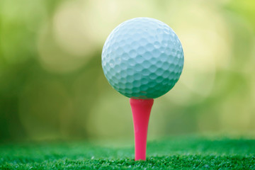 Golf ball on tee in beautiful golf course at bokeh background. Golf ball on green in golf course