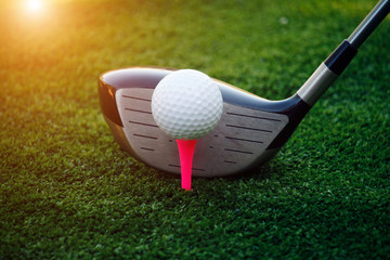 Golf ball and golf club in beautiful golf course at sunset background.