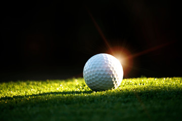 Golf ball on tee in beautiful golf course at night background. Golf ball on green in golf course