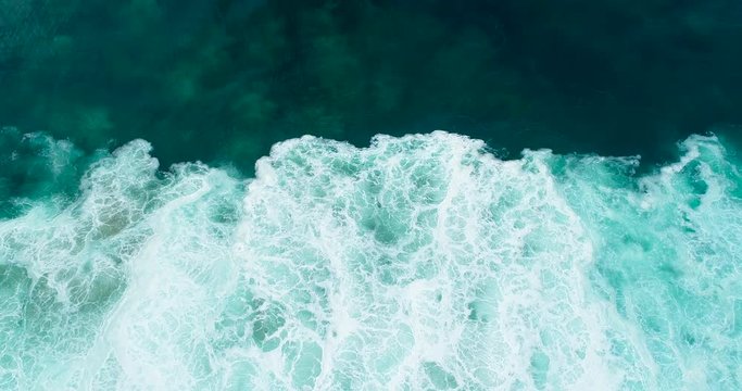 Top down aerial view of abstract ocean waves crashing creating unique patterns