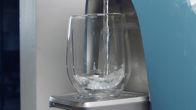 Slow motion of a water cup filling in a water filtering machine