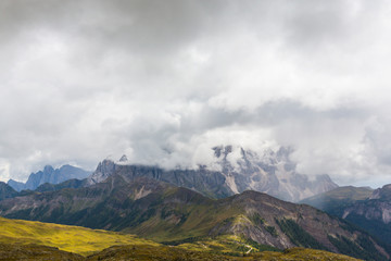 Naklejka na ściany i meble Beautiful scenery in the Dolomite Alps, with rain clouds, mist, and limestone peaks