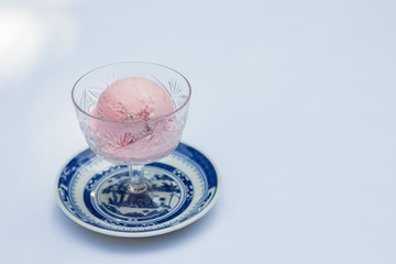 Strawberry ice cream in a glass on a white background