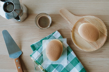 Wooden desk with Japanese cheesecake and cup of coffee in morning, Top view, Flat lay.