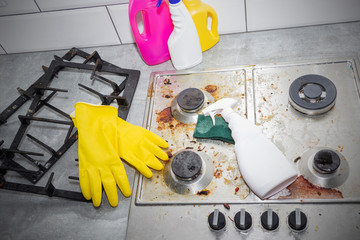 Cleaning a gas stove with kitchen utensils, household concepts, or hygiene and cleaning.