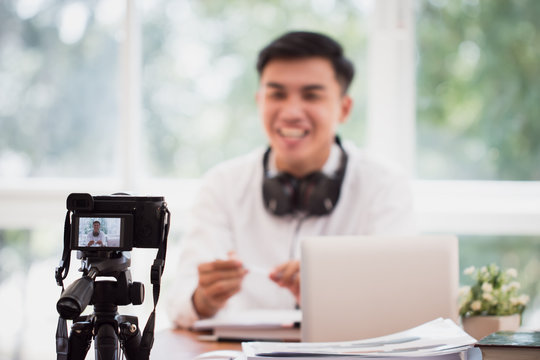 Happy Asian businessman videoblog / blogger vlogger recording online course or tutorial strategy presentation pass video for teaching live marketing sharing social media channel by mirrorless camera