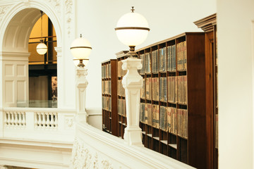 Shelf in an old library setting with old books on the shelf.