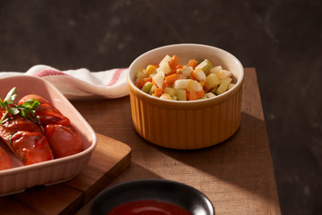 Grilled sausages with sauce ketchup on a wooden table