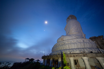Fototapeta premium moon and star above the head of Phuket big Bubbha brfore sunrise