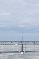 Fototapeta na wymiar Modern lighting & security cctv camera in cargo port with nothing to show for but protected land.