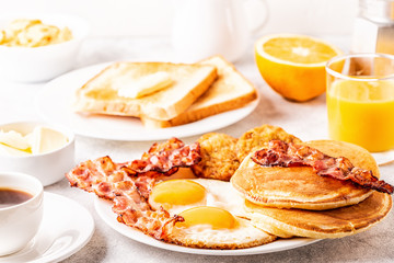 Healthy Full American Breakfast with Eggs Bacon Pancakes and Latkes.