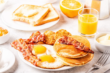 Healthy Full American Breakfast with Eggs Bacon Pancakes and Latkes.
