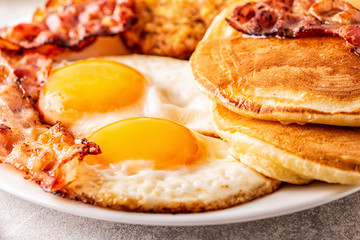 Healthy Full American Breakfast with Eggs Bacon Pancakes and Latkes.