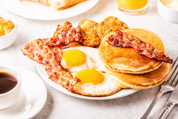 Healthy Full American Breakfast with Eggs Bacon Pancakes and Latkes.