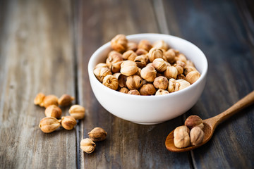 Dried cardamom pod in a bowl and wooden spoon on wooden table, herbs and spices, food ingredients