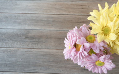 Retro image, pink and yellow flower in bamboo vase on table, vintage background,