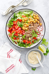 Healthy and delicious bowl with buckwheat and salad of chickpea, fresh pepper and lettuce leaves. Dietary balanced plant-based food. Vegan and vegetarian dish. Top view. Flat lay