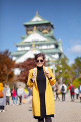 Fototapeta premium asian woman tourist taking a photograph at osaka castle one of most popular traveling destination in japan