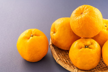 Beautiful and delicous tangerine isolated on airy blue background with bamboo sieve, new modern concept of chinese new year, close up, copy space