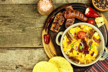 Scrambled egg with grilled sausage. Protein diet. A generous breakfast. Food preparation.